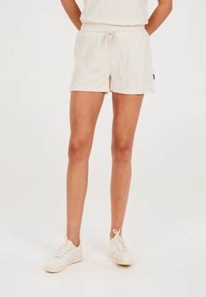 Witte textuur shorts met een elastische tailleband en een trekkoord. Gecombineerd met lichtgekleurde sneakers. Eenvoudig en casual ontwerp.