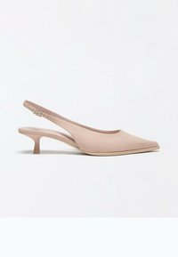 Chaussure slingback beige à bout pointu avec un petit talon kitten et une bride réglable à boucle sur fond blanc.