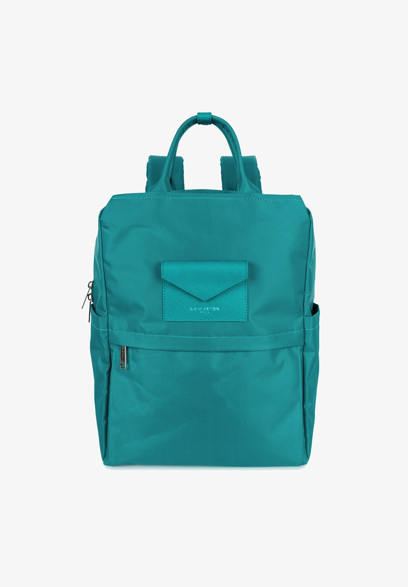 Sac à dos en nylon teal avec bretelles doubles, poigné supérieure, poche frontale à rabat et poche latérale zippée. Texture lisse et design épuré.
