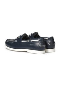 Marineblaue Lederbootsschuhe mit weißer Naht, Schnürsenkeln und einer Gummisohle. Sie verfügen über eine abgerundete Zehenform und minimale Hardware-Details.