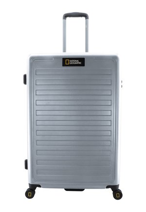 Silberner Hartschalenkoffer mit horizontalen Rillen, ausziehbarem Griff und vier schwarzen Rädern. Enthält ein National Geographic-Logo auf der Vorderseite.