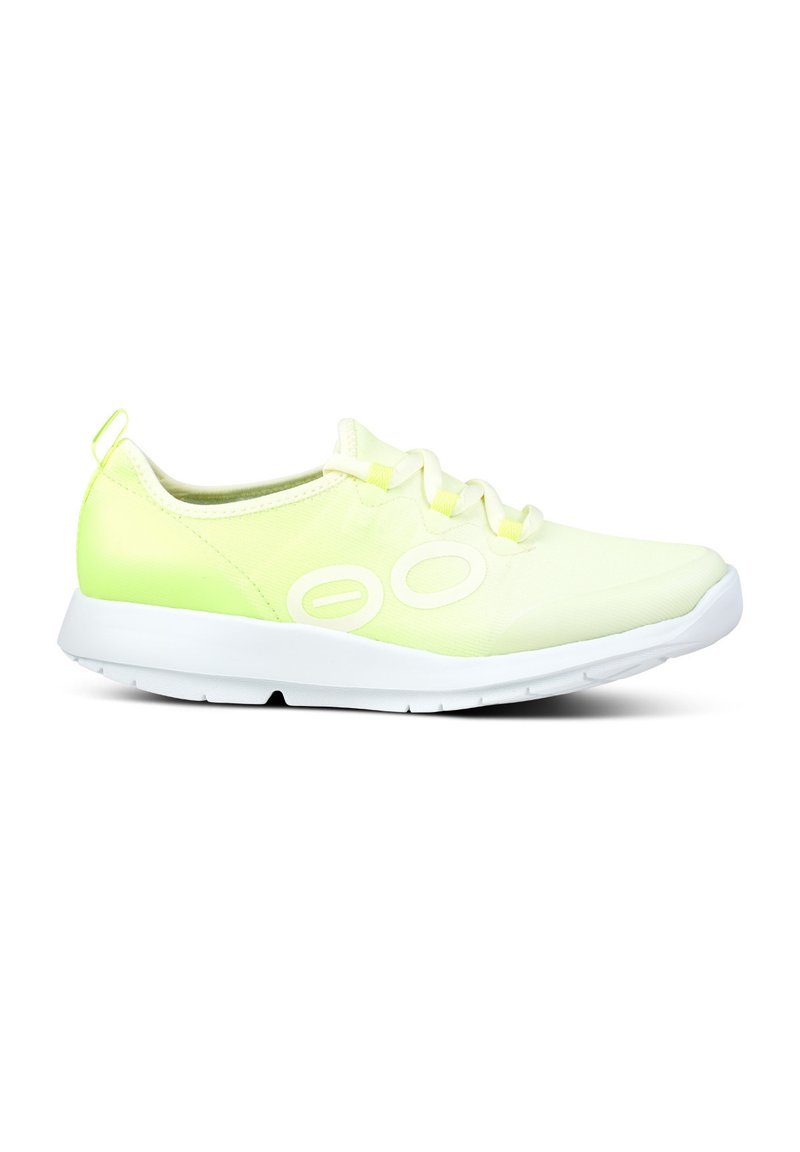 Limetkově zelená atletická bota s hladkým, lehkým textilním svrškem, bílými tkaničkami a bílou gumovou podrážkou; má embosované detaily na bocích.