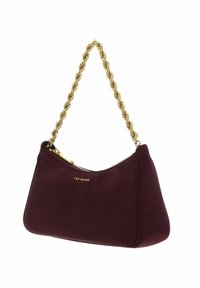 Bordeauxrode stoffen handtas met een gestructureerde gouden kettingband, voorzien van een ritssluiting en het merklogo in reliëf aan de voorkant.