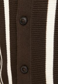 Braun-weiße gestreifte Strickjacke aus strukturiertem Stoff, mit einem schwarzen Knopf und kontrastierenden Streifendetails.
