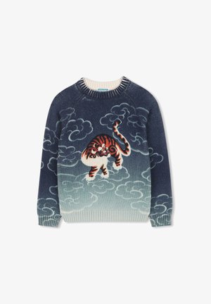 Pull bleu marine avec des motifs de nuages bleu clair et un design central représentant un tigre orange et blanc marchant parmi les nuages.