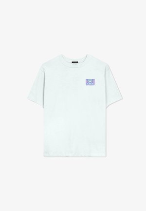 T-shirt di cotone azzurro chiaro con collo rotondo. Presenta una piccola grafica di una montagna in un design rettangolare sul lato sinistro.