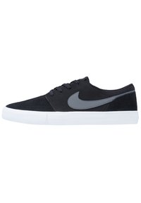 Mustat mokkanahkaiset lenkkarit, joissa on harmaa Nike-logon swoosh, valkoisella kumipohjalla ja klassisella nauhakiinnityksellä. Sileä pinta ja virtaviivainen muoto.
