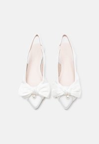 Λευκά τακούνια slingback με μυτερή μύτη, με εντυπωσιακό φιόγκο και διακόσμηση με μαργαριτάρι σε λείο ύφασμα που μοιάζει με σατέν.