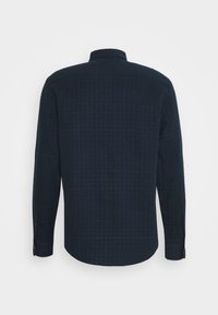 Tmavě modrá košile s dlouhým rukávem, textura s vzorem, knoflíkové manžety, rovný lem a klasický límec, zobrazující mřížkový design.