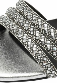 Sandal in argento con fascia a slip-on, dotata di tre cinturini decorati con strass trasparenti e una finitura metallica testurizzata sulla soletta.