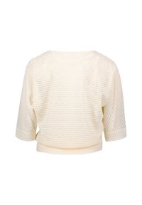 Blouse couleur crème avec un motif ondulé, coupe courte, manches trois-quarts et texture douce. La vue arrière montre un col arrondi.