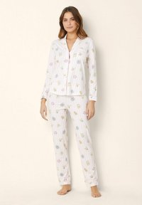 Set de pijama din bumbac cu un model cu dungi roz, prezentând ilustrații cu animale. Tops cu mânecă lungă și pantaloni lungi cu manșete.