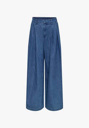 Plave hlače širokih nogavica od trapera s elastičnim pojasom, petljama za remen i naborima sprijeda, prikazane na bijeloj pozadini.