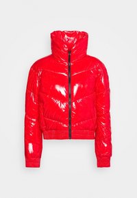 Czerwona puchowa kurtka o błyszczącej, pikowanej fakturze. Wysoki kołnierz, zamek błyskawiczny z przodu i ściągacze na rękawach. Krótki krój podkreśla nowoczesny styl.