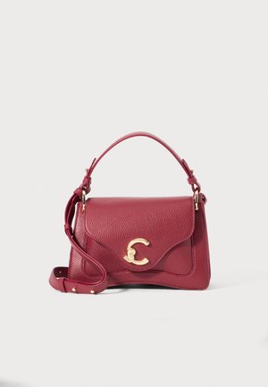 Burgundy leather handbag with a structured design, featuring a short top handle and a detachable strap. Gold logo accent on the front.