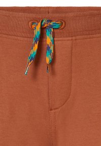 Bruine trainingsbroek met geribde tailleband en meerkleurige gevlochten koord. Voorzien van zijzak en een gladde textuur.