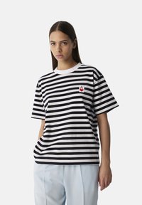 Czarny i biały pasek t-shirt z okrągłym białym dekoltem i krótkimi rękawami, z małym logo płomienia w kolorze czerwonym i żółtym na lewej piersi.