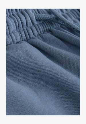 Mješavina pamuka u mekoj plavoj boji, sa naboranim pojasom i uloženom žicom, prikazom vidljive teksture i detalja šavova.