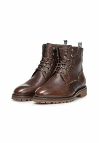 Bottines en cuir marron avec une finition texturée, présentant un design à lacets, un bout rond et une semelle en caoutchouc robuste. Accentué par des œillets métalliques et une languette de préhension.