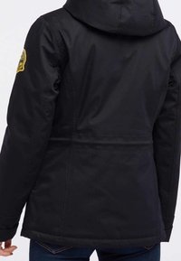 Czarna kurtka wierzchnia z kapturem, o dopasowanym kroju, z przeszyciami i okrągłą naszywką z logo na lewym ramieniu.