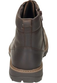 Stivale alla caviglia impermeabile marrone con tomaia texturizzata, pannello elastico laterale e cerniera posteriore. Include una suola in gomma resistente per una migliore aderenza.