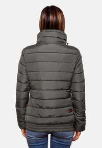 Giacca puffer grigia scura con colletto alto, cuciture orizzontali e texture liscia. Presenta un'etichetta decorativa vicino all'orlo.