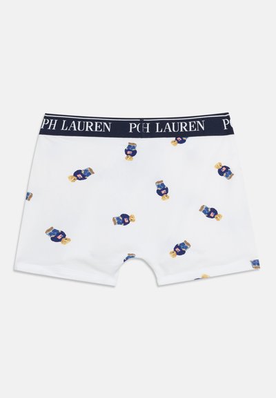 Λευκά μπόξερ με ναυτικό μπλε ζωνάκι, με διασκορπιστά σχέδια αρκουδάκια που φορούν μπλε πουλόβερ και μικρές λεπτομέρειες με την αμερικανική σημαία.