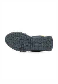 Suola di scarpa in gomma nera con motivo a grip circolare e scanalature, dotata di pomelli rialzati per una maggiore aderenza. Il design è fluido e funzionale.