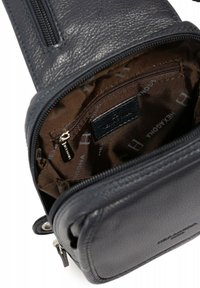 Borsa in pelle blu navy con superficie texture, dotata di un compartimento con zip e un rivestimento interno marrone con un motivo a logo ripetuto.
