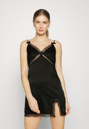 Black satin camisole dress featuring lace trim, adjustable straps, and front slit with a bow accent. Smooth texture and fitted design.