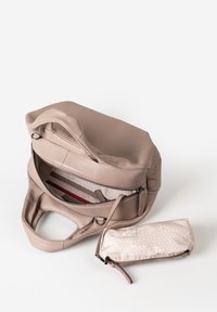 Borsa a mano in pelle beige con cerniera aperta, che rivela tasche interne, accompagnata da un piccolo astuccio beige con motivo, dotato di zip e tracolla.
