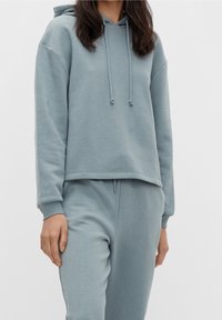 Felpa con cappuccio azzurro chiaro realizzata in tessuto morbido con vestibilità comoda. Presenta stringhe e polsini a coste per un maggiore comfort.