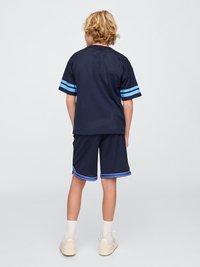 Jersey atlético de color navy con mangas a rayas azules, acompañado de pantalones cortos a juego. Textura de malla, con detalles en azul y blanco en los dobladillos.