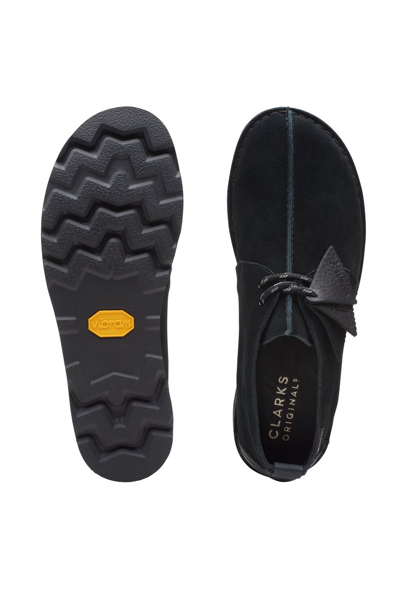 Schwarze Wildleder-Clarks-Originals-Schuhe mit gezackter Vibram-Sohle, mit Draufsicht und detailliertem Sohlenmuster.