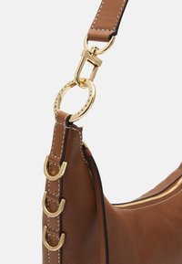 Hnědá kožená kabelka s akcenty ze zlatého kovu, texturovaným povrchem a odnímatelným popruhem s ladícími švy.
