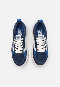 Vans tenisice s gornjim dijelom od tamnoplave i plave tekstilne tkanine, bijelim vezicama i bijelim bočnim prugama. Udobna potplata s teksturiranom površinom.