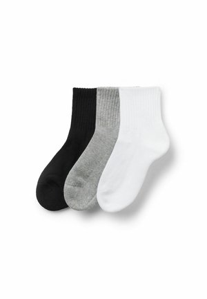 Drei Paar gerippte Socken in Schwarz, Grau und Weiß, ordentlich nebeneinander auf einem weißen Hintergrund angeordnet.