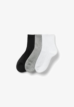 Trois paires de chaussettes à côtes pour homme en noir, gris et blanc, soigneusement disposées côte à côte sur un fond blanc.