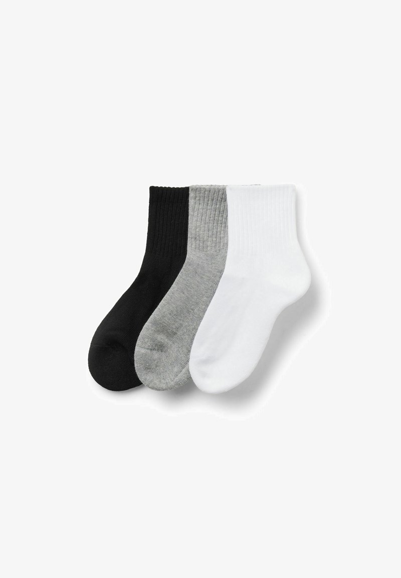 Trois paires de chaussettes à côtes pour homme en noir, gris et blanc, soigneusement disposées côte à côte sur un fond blanc.