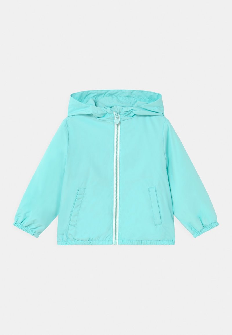 Veste à capuche bleu sarcelle clair en matériau lisse avec des poignets élastiques et une fermeture éclair sur le devant. Elle comprend deux poches latérales.