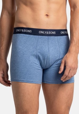Mandlig torso iført lyseblå boxershorts med navyblåt linning mærket "ONLY & SONS", stående mod en ensartet hvid baggrund.