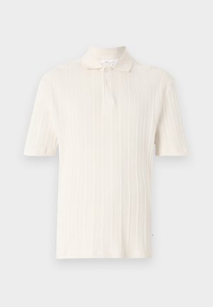 Kortärmad polotröja i mjuk krämfärgad tyg med vertikal ribbad struktur, har en klassisk krage och tvåknappsstängning.