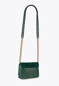 Borsa a spalla in pelle verde con patta in suede trapuntato, catena in metallo dorato e borchie alla base. Forma rettangolare compatta.