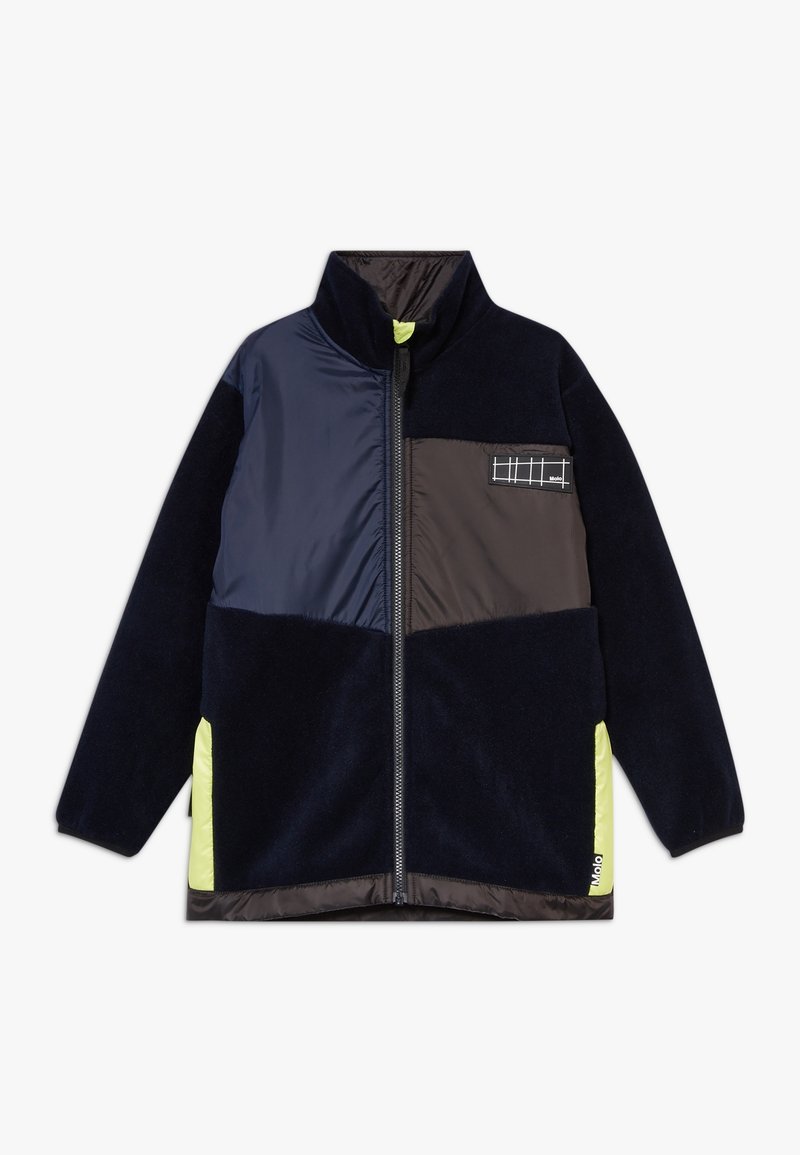 Veste en polaire présentant des panneaux bleu marine et noirs, une fermeture éclair sur le devant, un col montant et des accents vert fluo sur les côtés et l'ourlet inférieur.