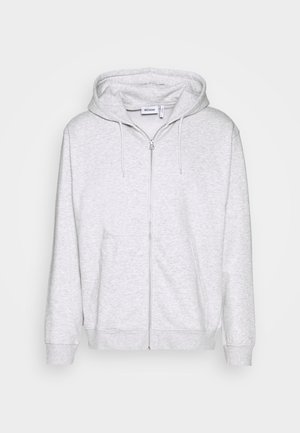Lys grå zip-up sweatshirt lavet af blødt stof. Har en frontlynlås, to sidelommer og en justerbar snor i hætten.
