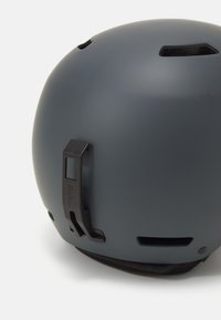 Casco da sci opaco grigio con aperture per la ventilazione, una clip nera regolabile e un morbido rivestimento interno per il comfort. Forma arrotondata per la sicurezza.