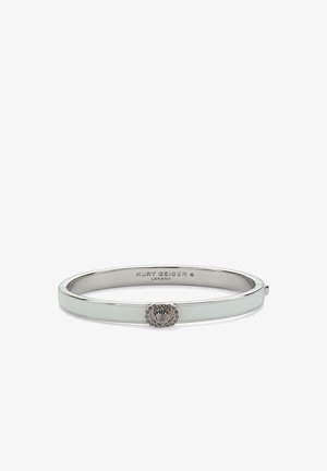 Srebrny, metalowy bransoletka z małym dekoracyjnym emblem i wygrawerowaną nazwą marki Kurt Geiger London wewnątrz.