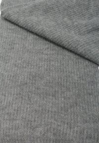 Sciarpa lavorata a maglia grigia, con una texture a coste e dettagli fini, arricchita da un logo discreto. Materiale morbido simile alla lana, piegata nella parte superiore.