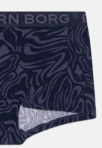 Mörkblå boxerbriefs med ett svallande, abstrakt mönster i en ljusare nyans, med en elastisk midjeband märkt "BORG." Mjuk tygkänsla.