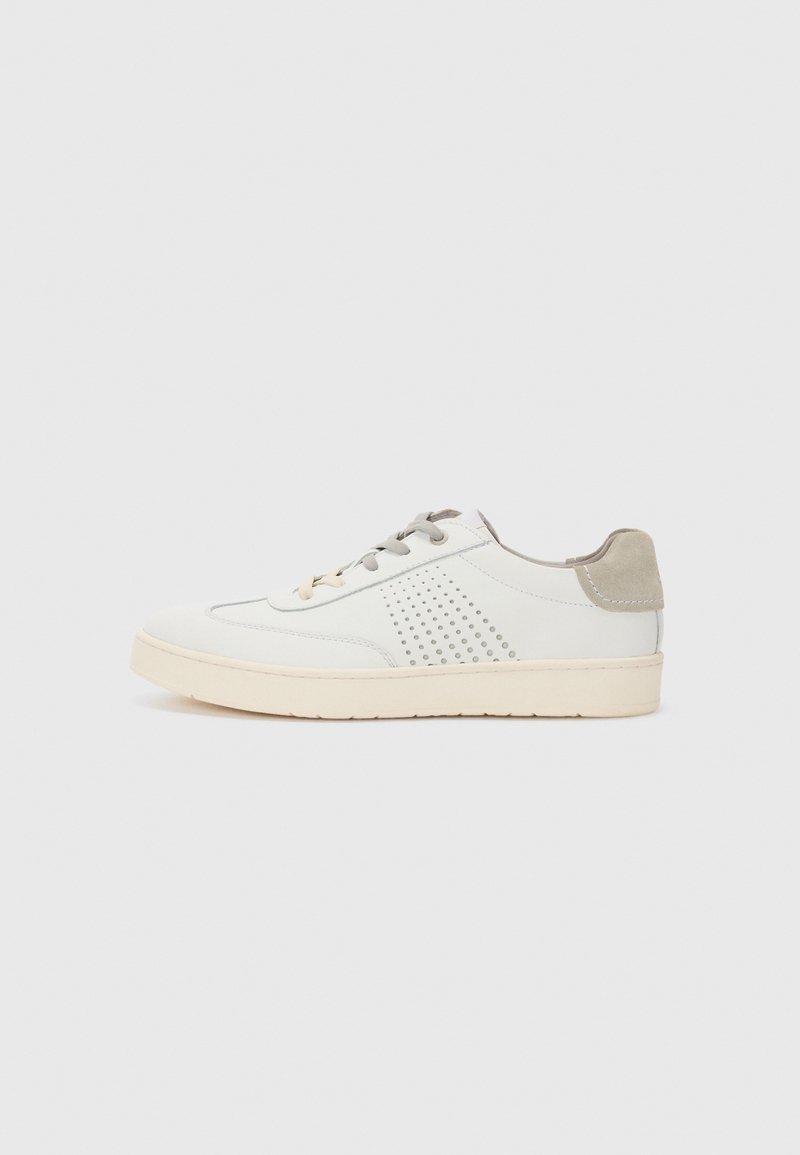 Hvit lær sneakers med beige detaljer, har perforerte detaljer, flate snører og en teksturert såle. Minimalistisk design.